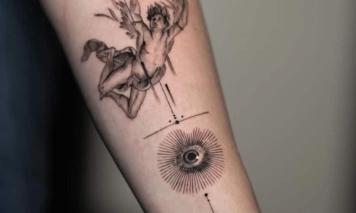 Tattoo of a flying figure with an eye motif on arm